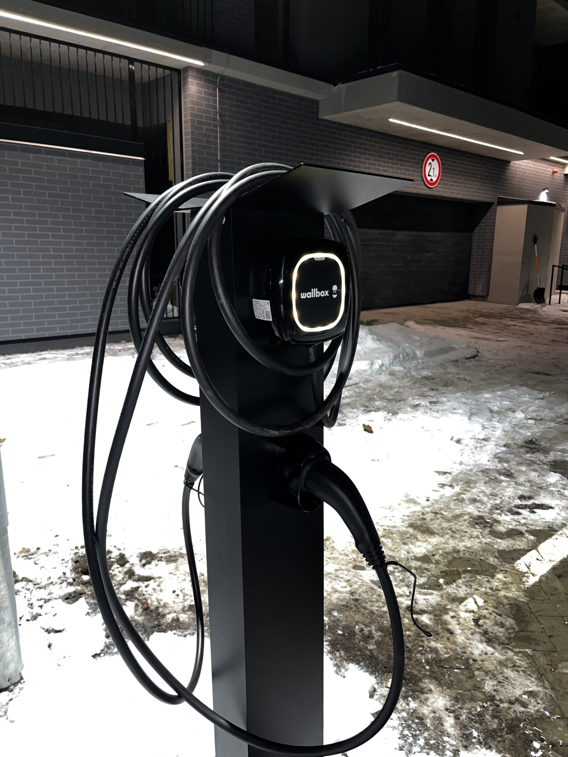 Uzlādes stacija daudzīvokļu nama virszemes stāvvietā, Rīgā